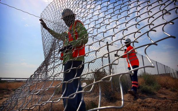 Caltrans highway maintenance workers, Don Causey, left, and Jason Bruins repair a fence along Interstate 15 in Eastvale in the blistering heat on Tuesday, June 21, 2016. Outdoor workers are suffering the most in this record-breaking June heatwave.